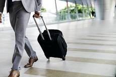 Viajero de negocios, en el aeropuerto con maleta.